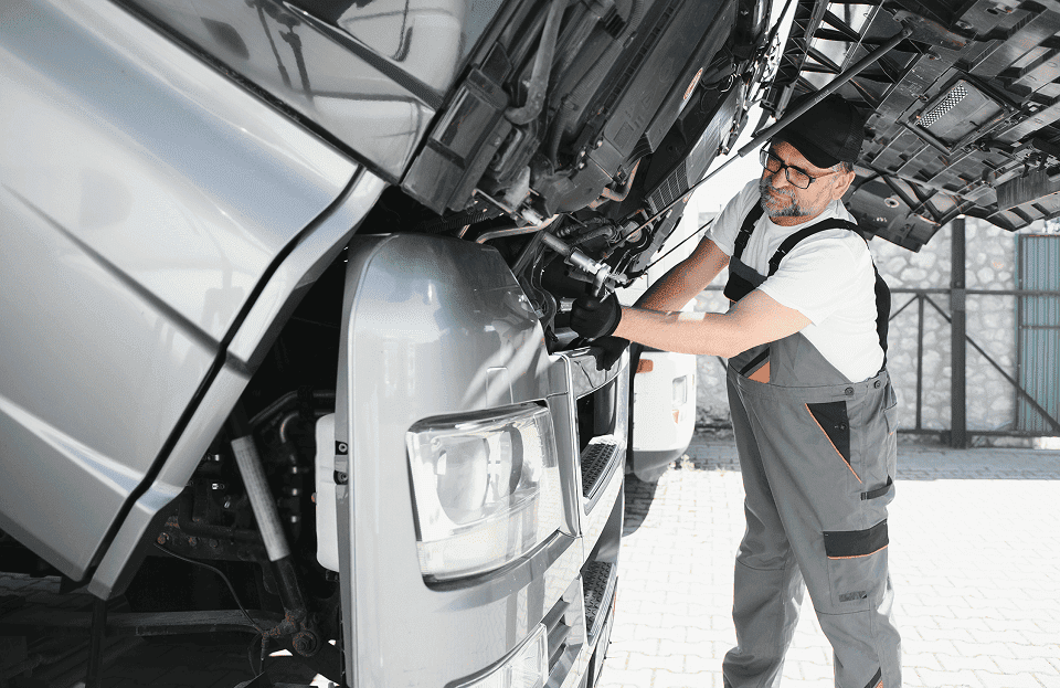 Technician working on truck collision repair in service bay